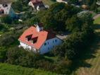 a large house with an orange roof on a hill at Hotel garni Zur Mühle in Angermünde