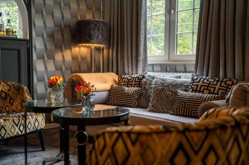 a living room with couches and tables and windows at Boutique Hotel Slenaker Vallei - Buitengewoongenieten in Slenaken
