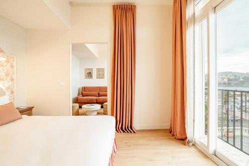 a bedroom with a bed and a large window at Villa Camille Hotel & Spa in Banyuls-sur-Mer