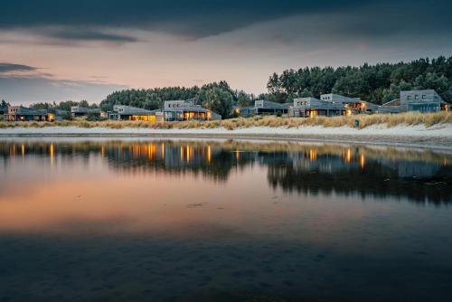 a group of houses sitting next to a body of water at Beach Resort Punt West in Ouddorp