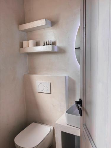 a small bathroom with a toilet and a sink at Elysian Villas Ios in Ios Chora