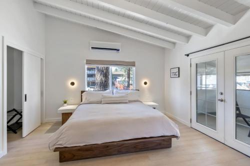 a white bedroom with a large bed and a window at South Lake Chalet by Heavenly in South Lake Tahoe