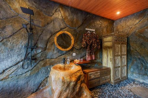 ein Badezimmer mit einem Waschbecken aus einem Baumstumpf in einem Zimmer in der Unterkunft Royal Agung Amertha Villa in Bedahulu