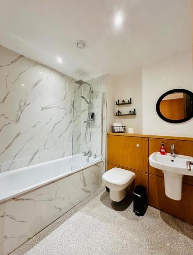 a bathroom with a tub and a toilet and a sink at Harbour Horizons in Edinburgh