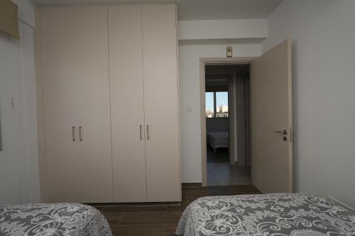Larnaca Salt Lake Gem, Airy 2 BDRM Apartment في لارنكا: غرفة نوم بسريرين وباب للحمام