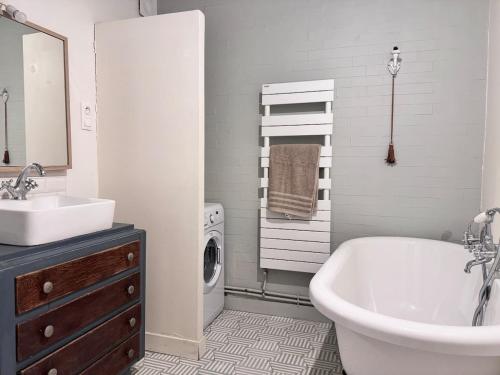 une salle de bains blanche avec un lavabo et une machine à laver dans l'établissement Sentier, à Paris