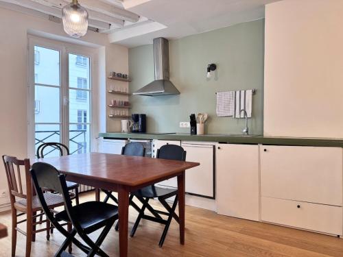 une cuisine avec une table et des chaises dans une pièce dans l'établissement Sentier, à Paris