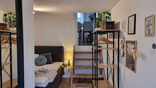 a room with a staircase and a bed in a room at Eigene Wohnung I St Gallen I Appenzell I Bodensee I St Anton I Seealpsee in Rebstein