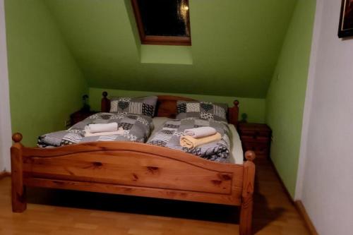 ein Bett in einem Zimmer mit grünen Wänden in der Unterkunft NEU! FeWo einfach Spreewald in Ruben