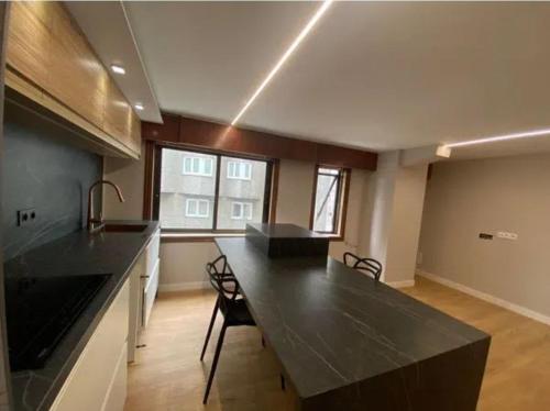 eine große Küche mit einer großen schwarzen Arbeitsplatte in der Unterkunft Dulzena Stay Apartments in A Coruña