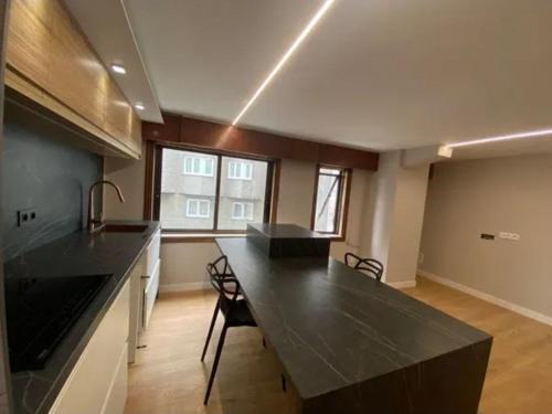 eine große Küche mit einer großen schwarzen Arbeitsplatte in der Unterkunft Dulzena Stay Apartments in A Coruña