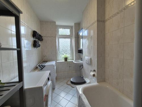 Un baño con bañera, inodoro y lavabo. en Mikra Homes24 in Chemnitz, en Chemnitz