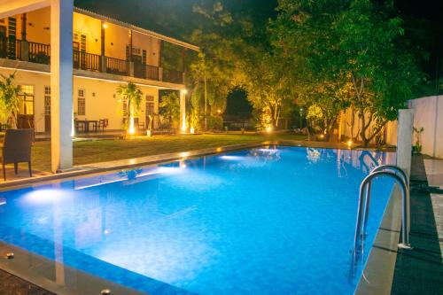 a large swimming pool at night with a building at Ovenro Safari Hotel & Restaurant Yala, Kataragama in Kataragama