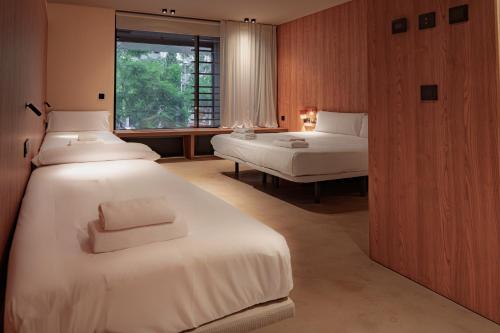 CASA ROMA Hostel Boutique في تاراغونا: غرفة نوم بها سريرين ونافذة