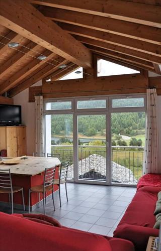 a living room with a table and a couch at Chesa Tre Piz in Maloja