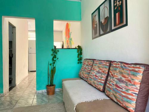 een woonkamer met een bank en een blauwe muur bij AeroSol Espaço Inteiro - Casa in Aracaju