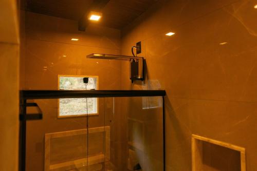 un bagno con doccia con porta in vetro di Herança do Vovô02 a Domingos Martins