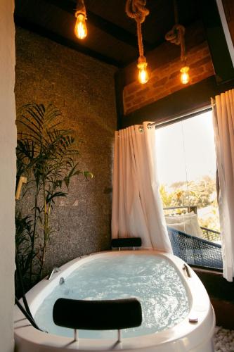a bath tub in a bathroom with a window at Herança do Vovô02 in Domingos Martins