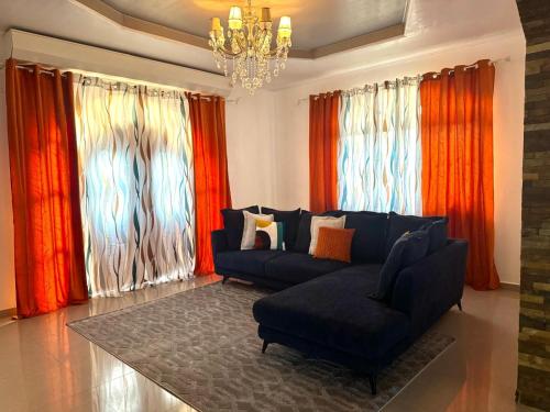 a living room with a couch and red curtains at La maison blanche in Macouria