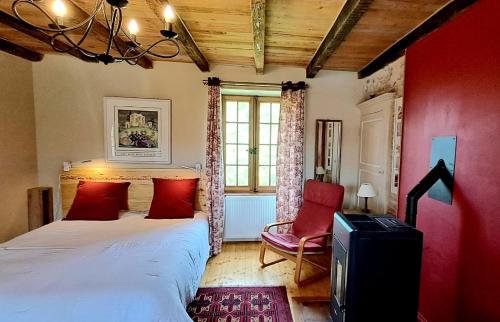 Saint-PointにあるLa Chenevièreの赤い壁のベッドルーム1室(ベッド1台付)