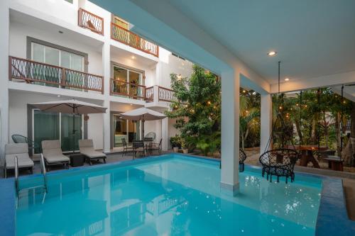 a swimming pool in front of a building at Hotel Caracol Isla Mujeres in Isla Mujeres