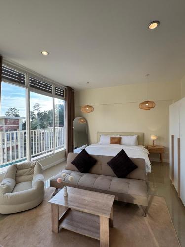 a large bedroom with a bed and a couch at TIL DAWN Phuket in Karon Beach