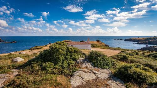 a small building on a hill next to the ocean at Maison Harmonie entre Ocean et Nature in Saint-Jean-de-Monts