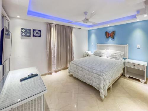 a bedroom with a bed and a blue wall at Garden Condo in Sosúa
