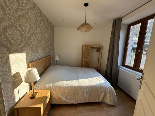 Appartement 4 personnes في أوربي: غرفة نوم بها سرير ومصباح ونافذة