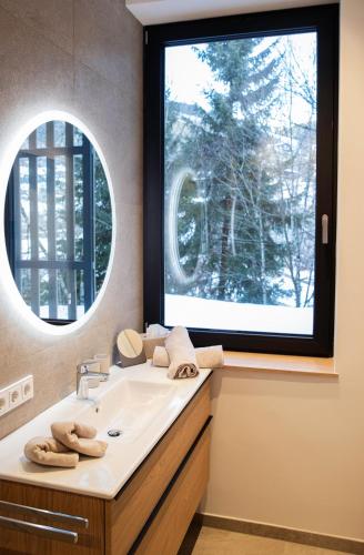 a bathroom with a sink and a large window at Appartement Chalet Saalbach - incl Joker Card in Saalbach-Hinterglemm