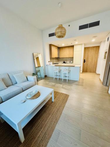 a living room with a couch and a table at Elegant Haven by Meraki - New 1 Bed Garden View in Dubai