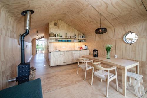 Huisje met uitzicht op de polder aan het water في Oud-Ade: مطبخ وغرفة طعام مع طاولة وموقد