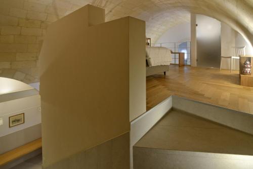 ein großer Raum mit einer Steinwand und ein Schlafzimmer in der Unterkunft aMate' Luxury slow living by BarbarHouse in Matera