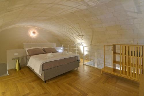 ein Schlafzimmer mit einem Bett in einer Ziegelwand in der Unterkunft aMate' Luxury slow living by BarbarHouse in Matera