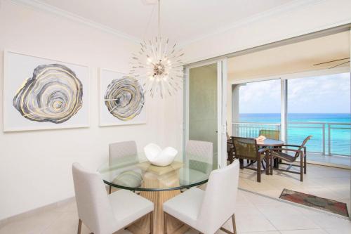 Un comedor con una mesa de cristal y sillas. en Beachcomber 21, en George Town