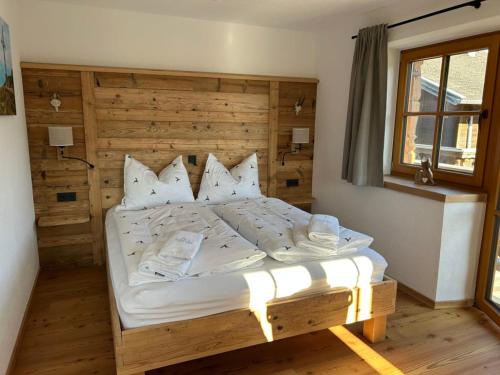 een slaapkamer met een bed met witte lakens en kussens bij Wimmerhof - Appartement Bergsonne in Breitenbach am Inn