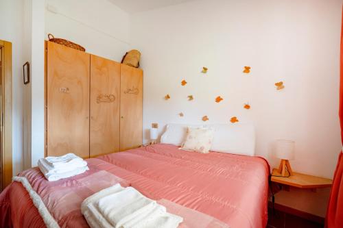 a bedroom with a bed with a pink comforter at Villa Ada in Cozze