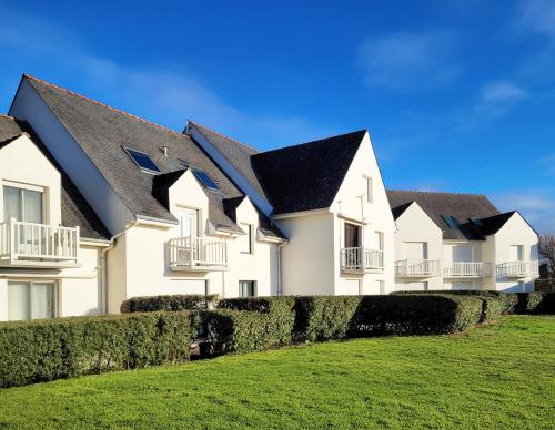 eine Reihe von weißen Häusern mit schwarzen Dächern in der Unterkunft Ker Eon - Les Gîtes de la Côte d'Amour in Batz-sur-Mer