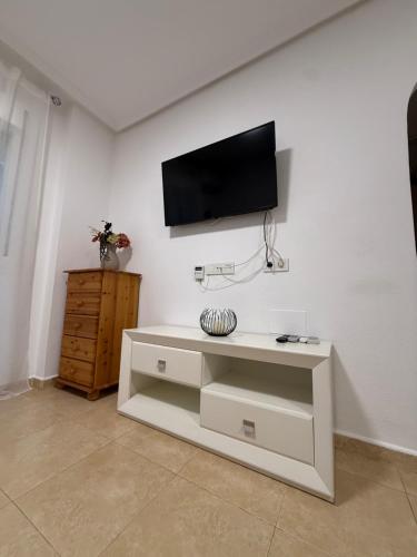 ein Wohnzimmer mit einem Fernseher an einer weißen Wand in der Unterkunft Casa Feliz in Torrevieja