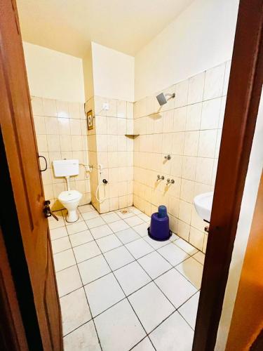 a bathroom with a toilet and a sink at Hotel Sai Sagar in Manipal