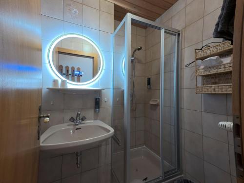 Un baño con ducha, lavabo y espejo. en Hotel-Gasthof Lammersdorf, en Millstatt