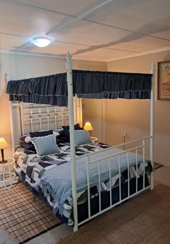 a bedroom with a canopy bed in a room at Glen House in Brenton-on-Sea