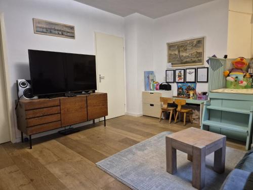 a living room with a flat screen tv on a dresser at Appartement met 2 slaapkamers en tuin in Amsterdam in Amsterdam