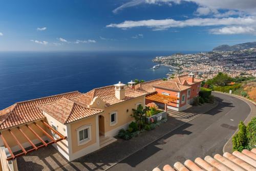 a house with a view of the ocean at Palheiro Village Resort in Funchal