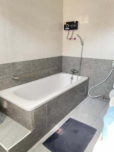 a bath tub in a bathroom with a shower at Small home in Ban Khlong Hok Wa