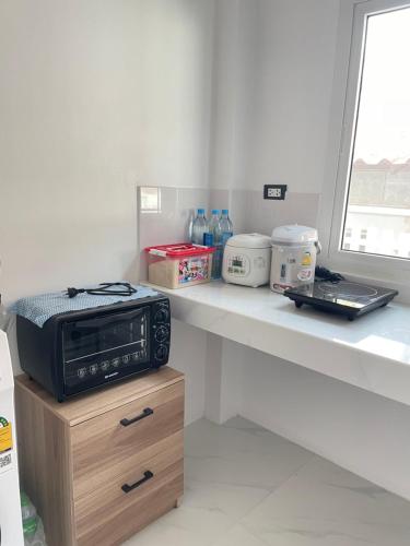 un micro-ondes posé sur un comptoir dans une cuisine dans l'établissement Small home, à Ban Khlong Hok Wa