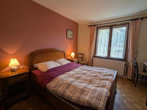 Chambre d'hôtes à Vecoux في Vecoux: غرفة نوم بسرير ومصباح ونافذة