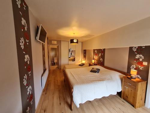 a bedroom with a large white bed and wooden floors at La Jinquette in Lantéfontaine