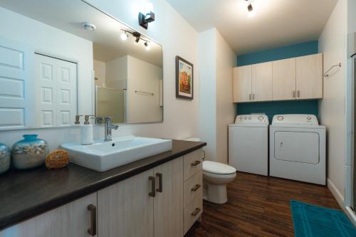 a bathroom with a sink and a washing machine at Spa privé et billard pret de la montagne de ski Stoneham 12 personnes in Stoneham