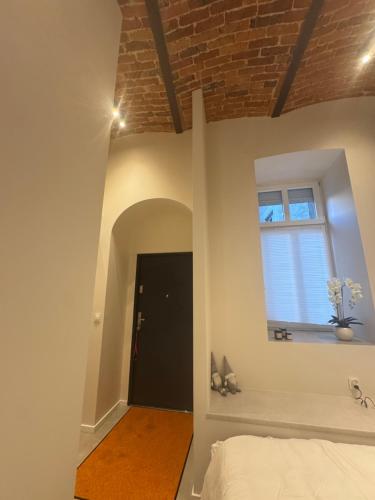 una camera da letto con pareti bianche e soffitto in mattoni di Old Town Pomorska Luxury Apartment a Breslavia